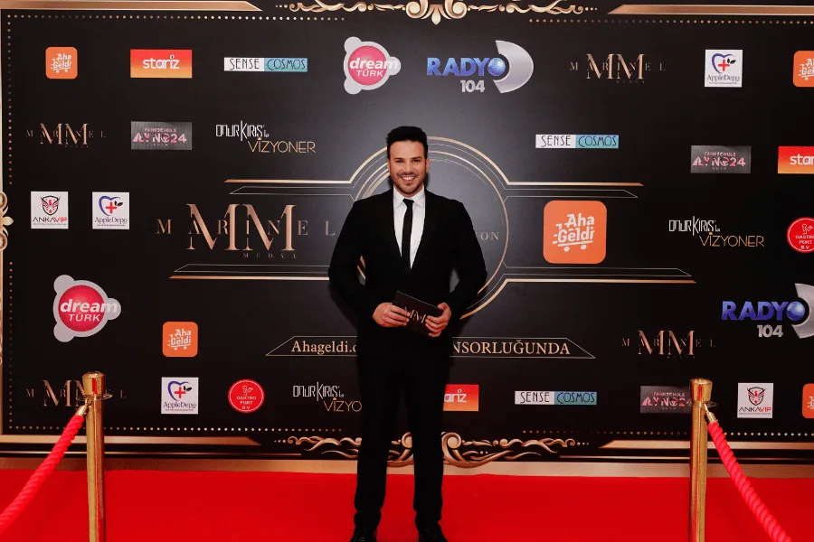 An interview in front of the red carpet and sponsor wall