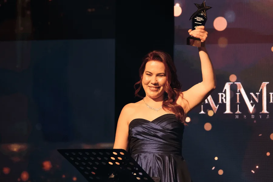 A recipient raising their award